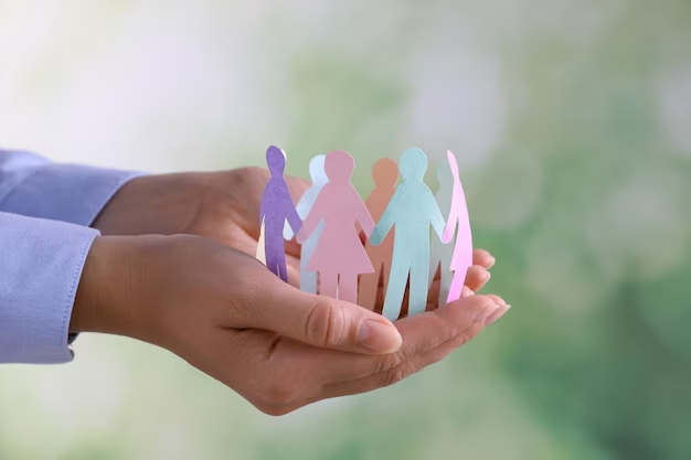 Open palm hand with paper humans on top holding each other's hands in a connected circle